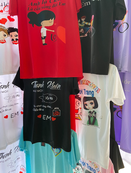 Áo thun cổ tròn unisex in màu với các slogan vui nhộn như "Thanh Xuân như một chén trà", "Anh là cầu vồng đời em", thiết kế trẻ trung, chất liệu cotton mềm mát.